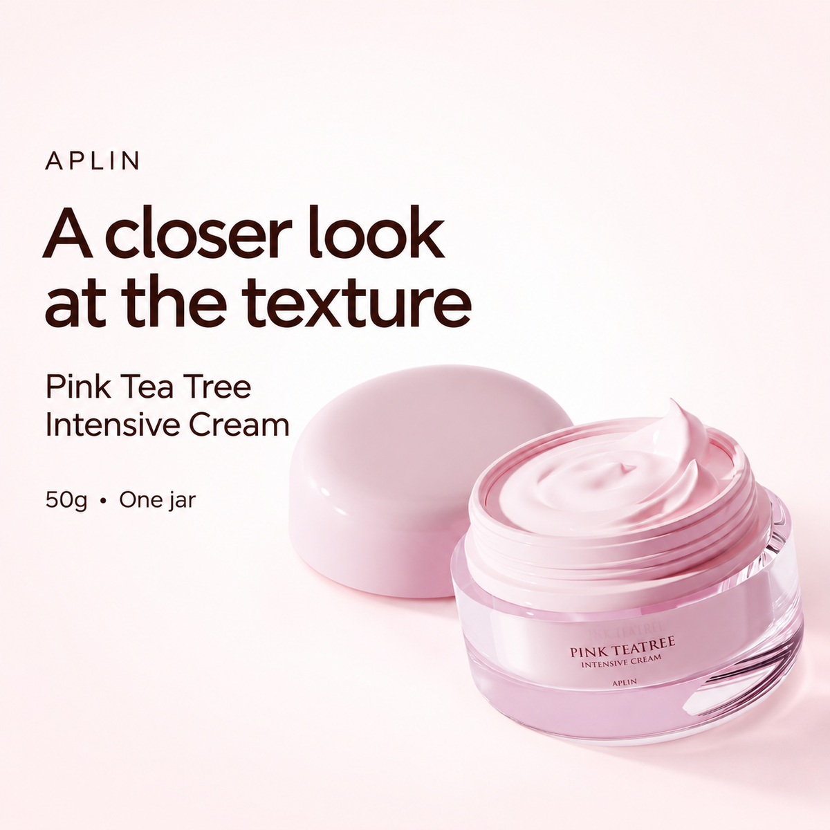 Close view of pink cream texture in an open APLIN Pink Tea Tree Intensive Cream jar with its lid.